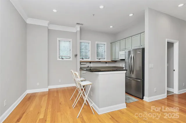 a kitchen with stainless steel appliances granite countertop a refrigerator a stove a sink and a microwave