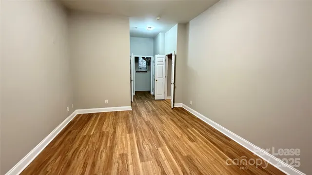 a view of hallway with a large window and wooden floor