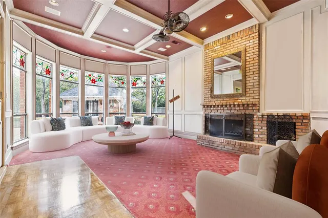 a living room with furniture a fireplace and a chandelier