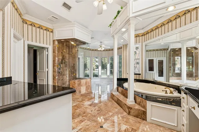 a large white kitchen with granite countertop a lot of windows and refrigerator