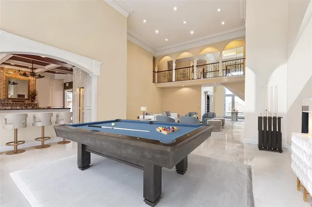 a living room with stainless steel appliances furniture a rug and a view of kitchen