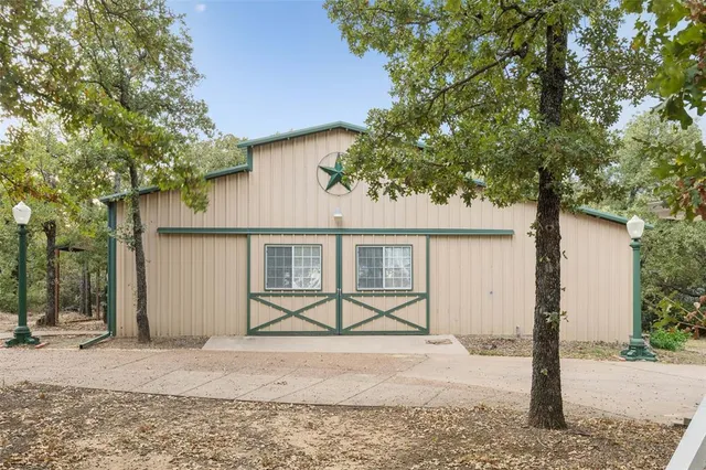 a view of a house with a tree and wooden fence