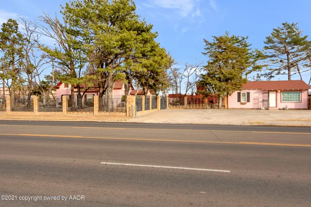 a front view of a building with trees and covered with snow