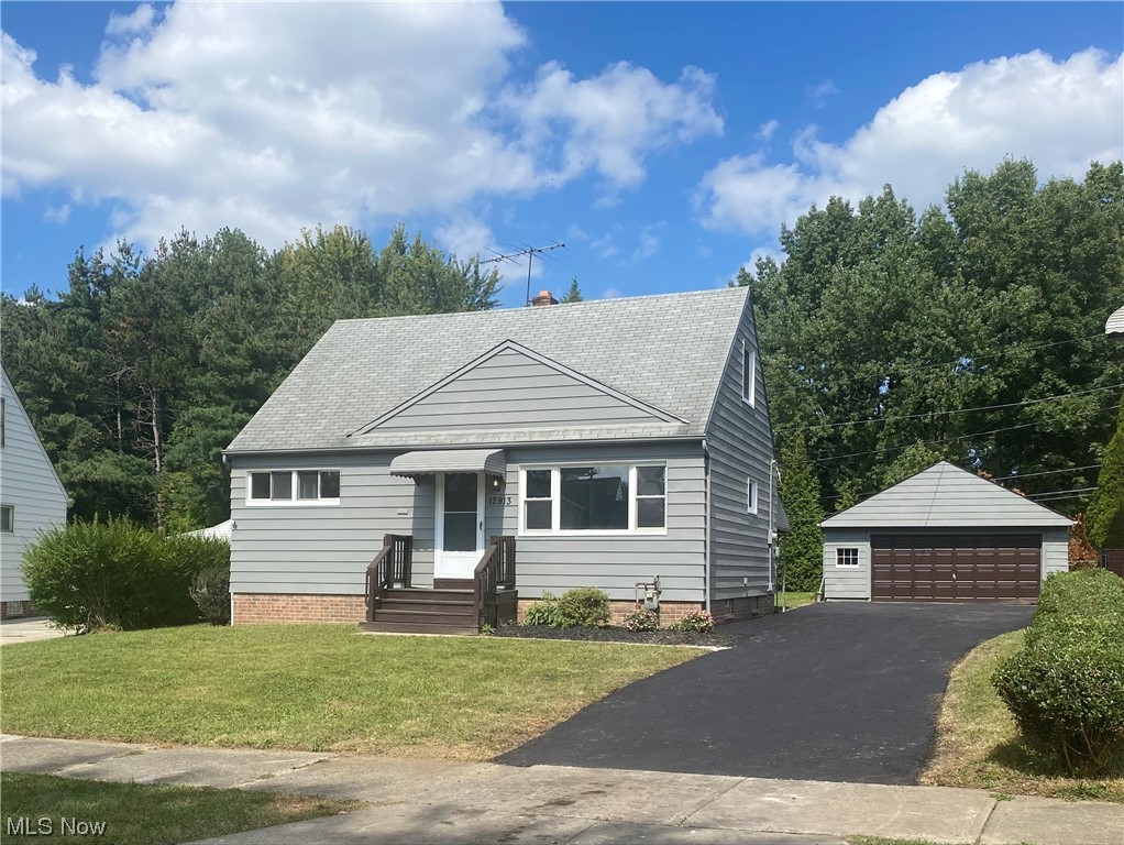 View of front facade featuring garage and a front lawn
