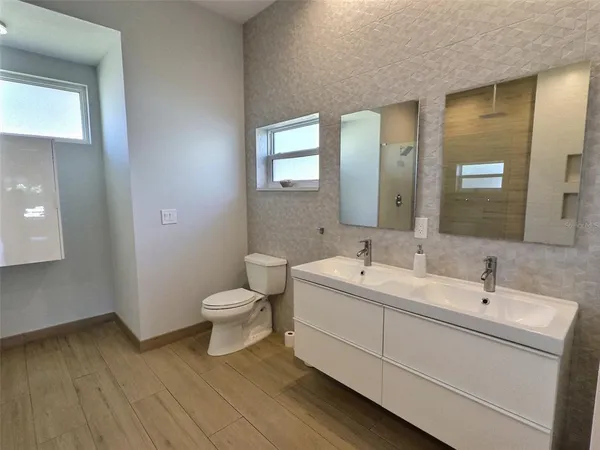 a bathroom with a toilet sink and mirror
