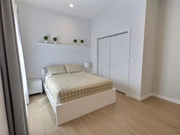 a bedroom with a bed and wooden floor