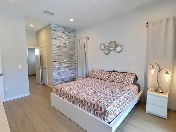 a bedroom with a bed and painting on the wall