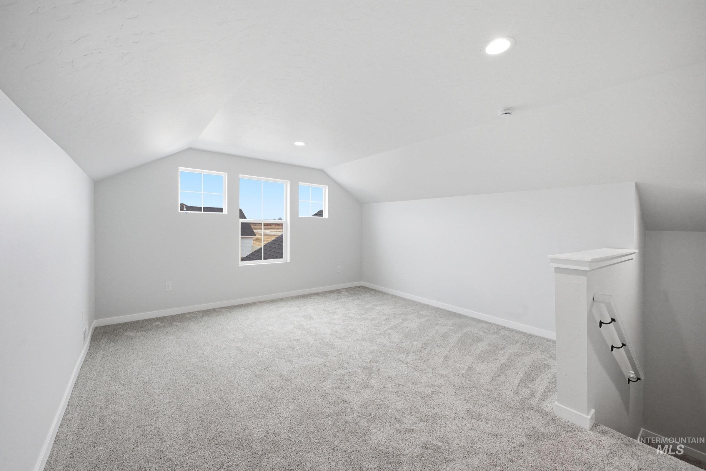 14104 Shiny Spruce Street Caldwell, ID 83607 - Photo 20 of 20 Carpeted upper-level space featuring vaulted ceilings, three windows with exterior views, recessed lighting, and a white balustrade