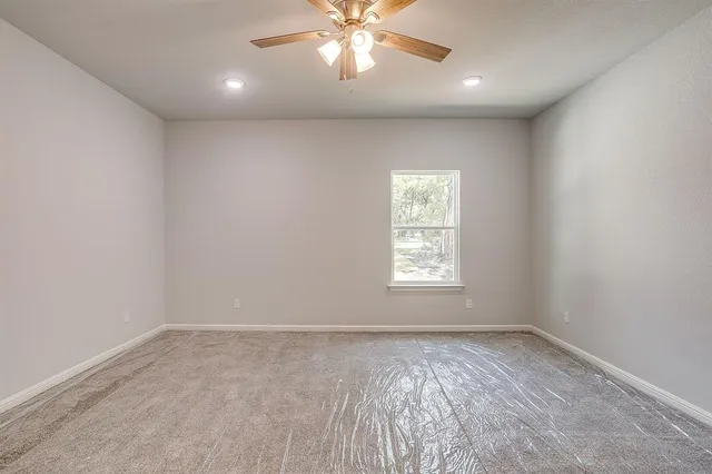 an empty room with white walls and bathroom view