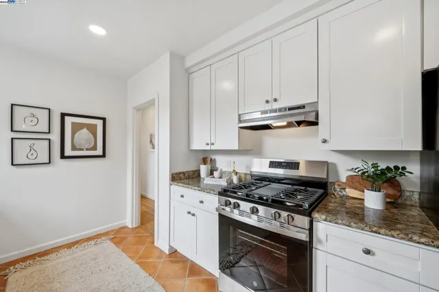 a kitchen with granite countertop cabinets and a stove top oven