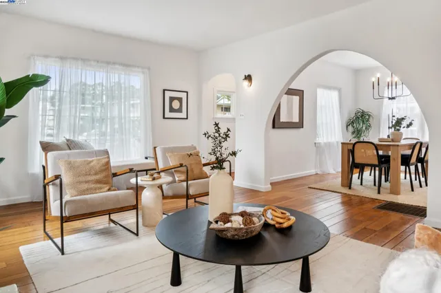 a living room with furniture a wooden floor and a floor to ceiling window