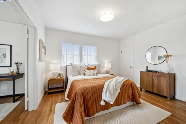 a bedroom with a bed a mirror and a dresser