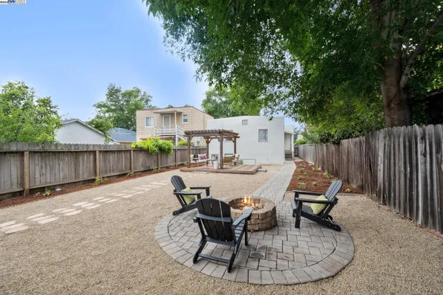 a view of a patio with table and chairs with wooden fence and plants