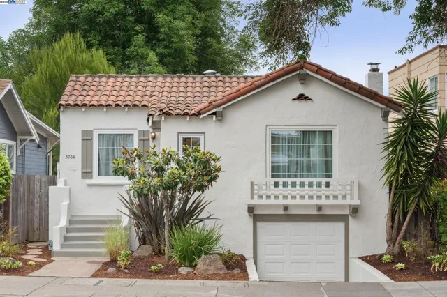 a view of a house with a yard and potted plants