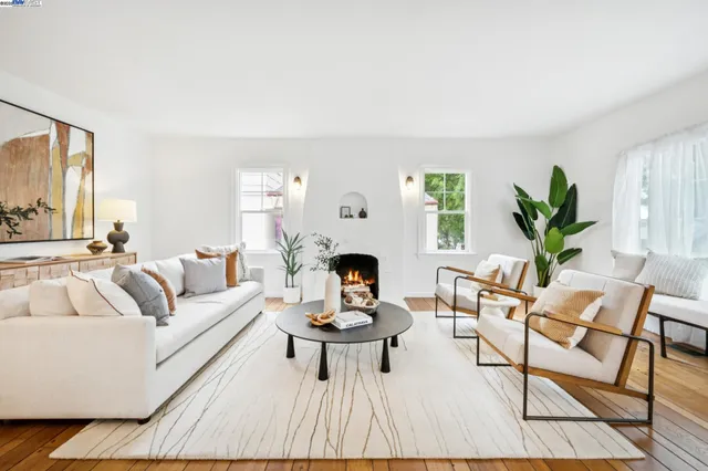 a living room with furniture a fireplace and a potted plant