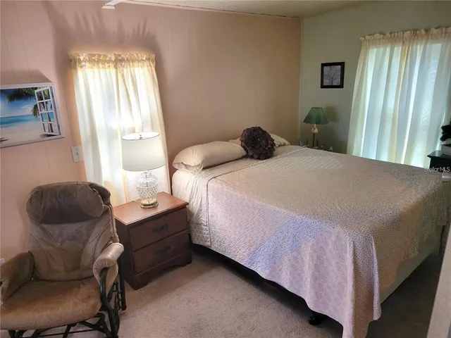 a bedroom with a bed chair and window