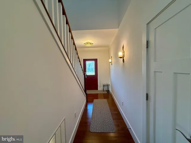 a view of a hallway with wooden floor and staircase