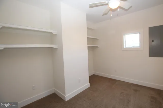 an empty room with a chandelier fan