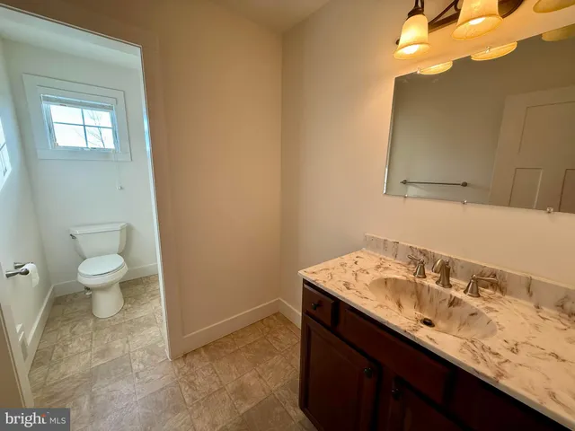 a bathroom with a sink a toilet and mirror