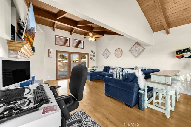 a living room with furniture a flat screen tv and kitchen view