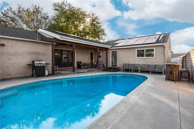 a view of a house with swimming pool and sitting area