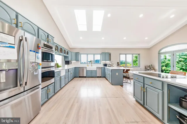 a large kitchen with stainless steel appliances and a large window