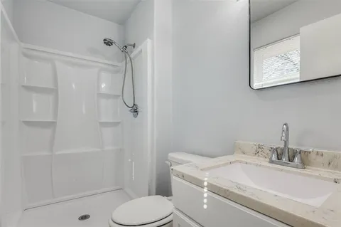 a bathroom with a sink a toilet and mirror