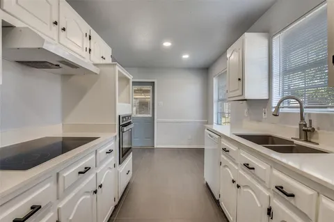 a kitchen with white cabinets and white appliances
