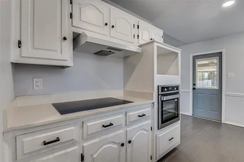 a kitchen with granite countertop white cabinets and white appliances