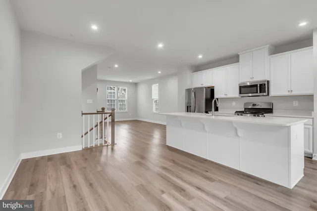 a view of kitchen with microwave a stove and wooden floors