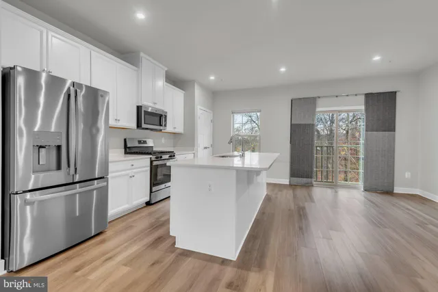 a kitchen with refrigerator cabinets and wooden floor