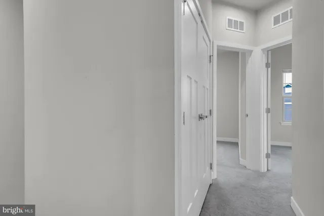 a view of a hallway with closet and wooden floor
