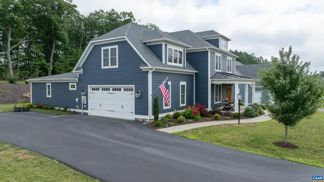 a front view of a house with garden and trees