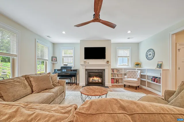 a living room with furniture a fireplace and a flat screen tv