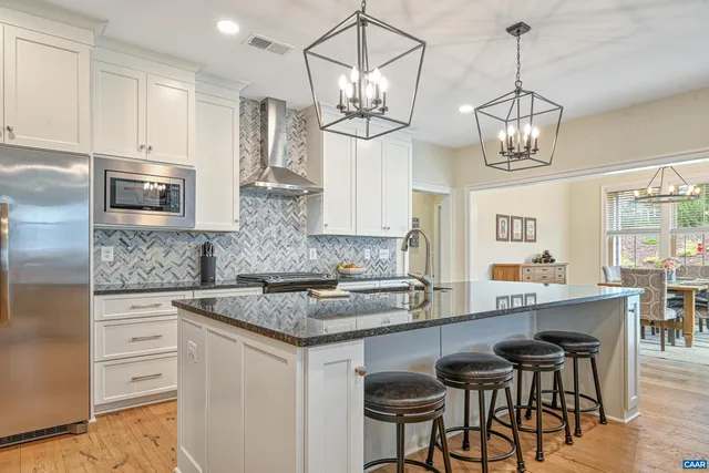 a kitchen with stainless steel appliances granite countertop a sink and a refrigerator