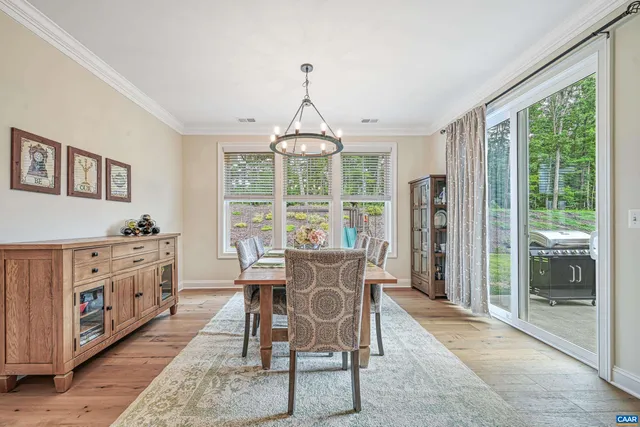 a dining room with furniture a chandelier and wooden floor