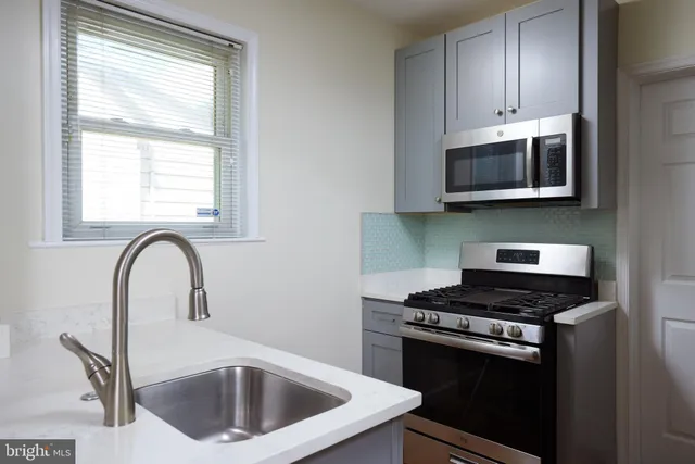 a kitchen with a stove a sink and a microwave