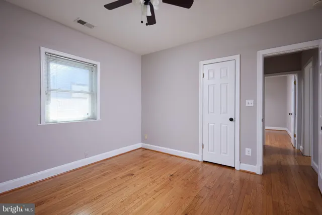a view of empty room with wooden floor