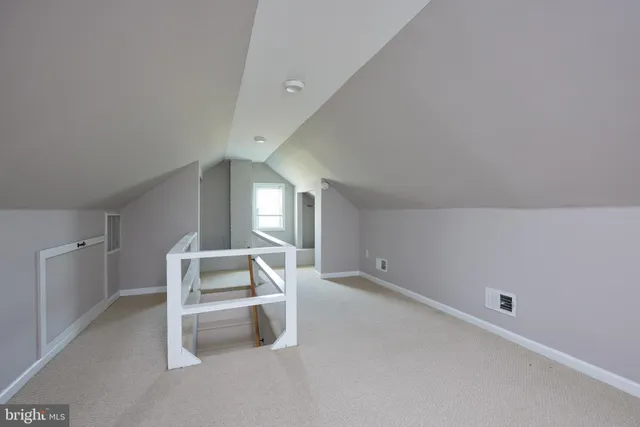 a living room with a bed and white walls