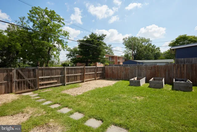 a view of a backyard with a garden and entertaining space