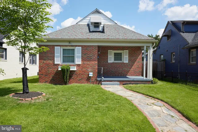 a front view of a house with yard and green space
