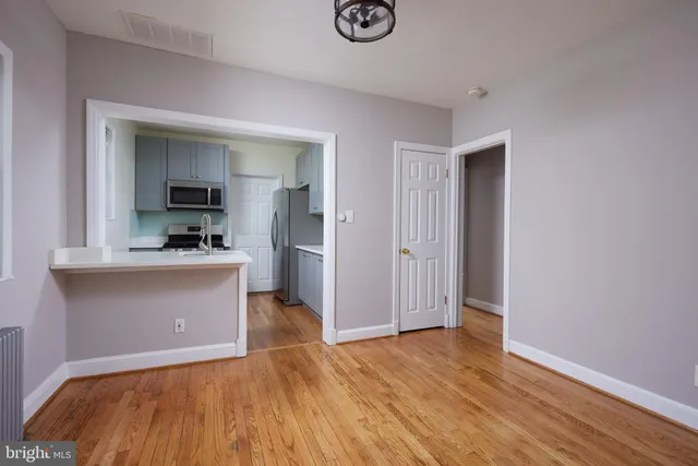 a view of kitchen and hallway with wooden floor