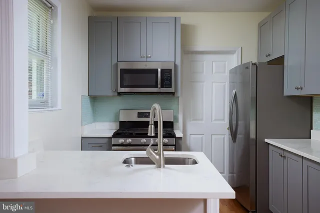 a kitchen with appliances a sink and cabinets