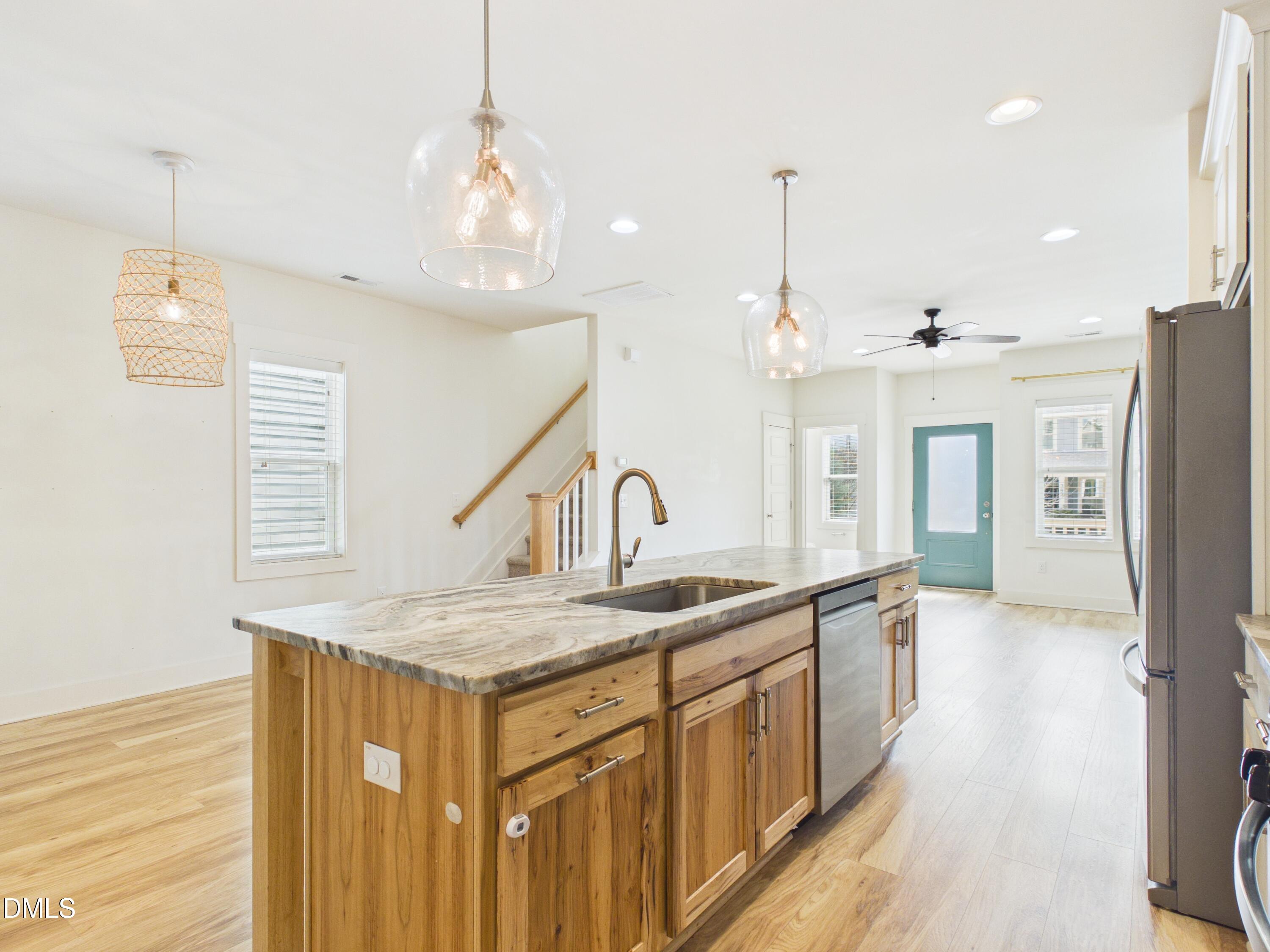 748 Groveview Wendell, NC 27591 - Photo 11 of 38 a kitchen with stainless steel appliances granite countertop a sink dishwasher and a refrigerator with wooden floor