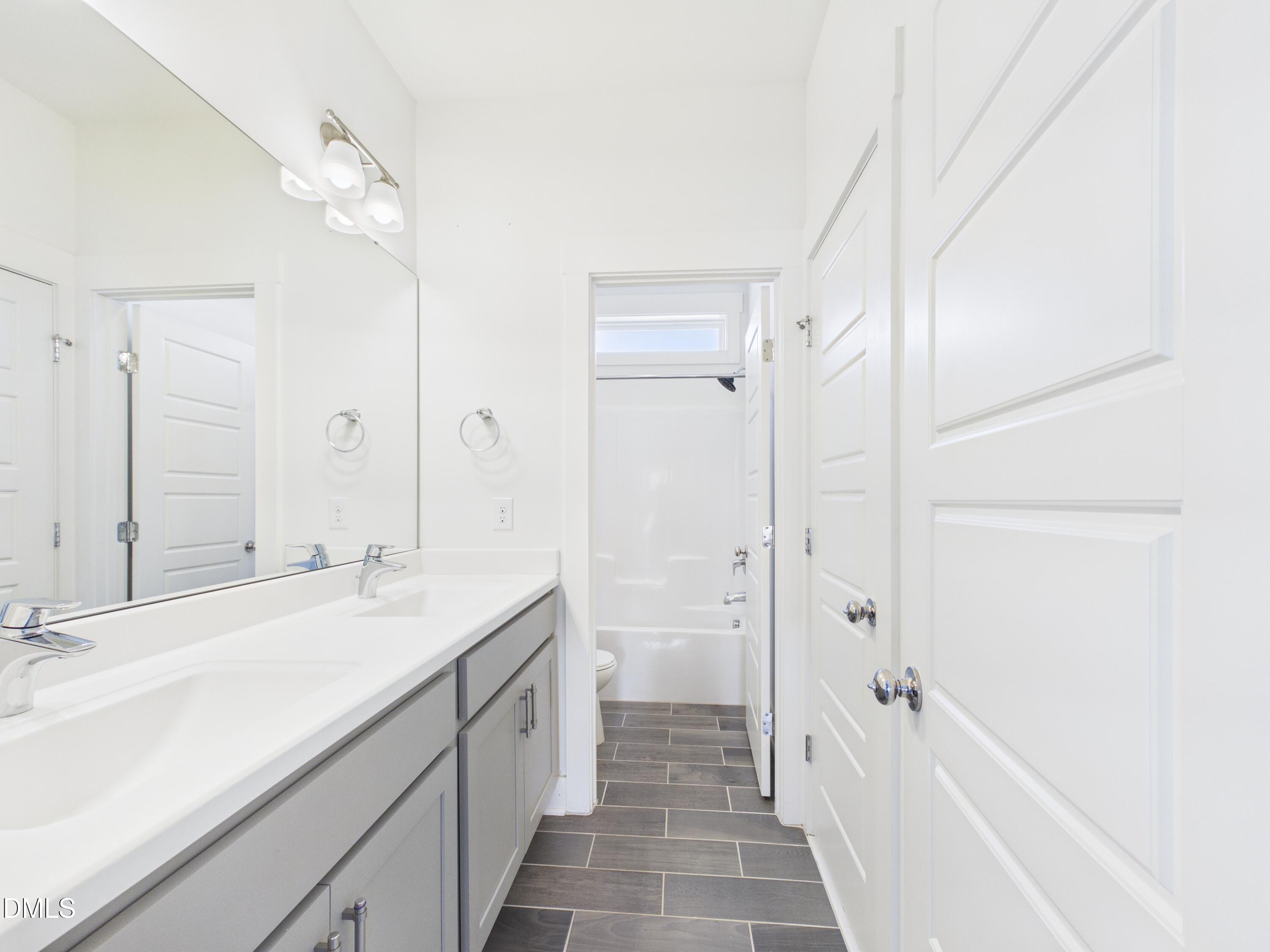 748 Groveview Wendell, NC 27591 - Photo 27 of 38 a spacious bathroom with a shower sink and a mirror
