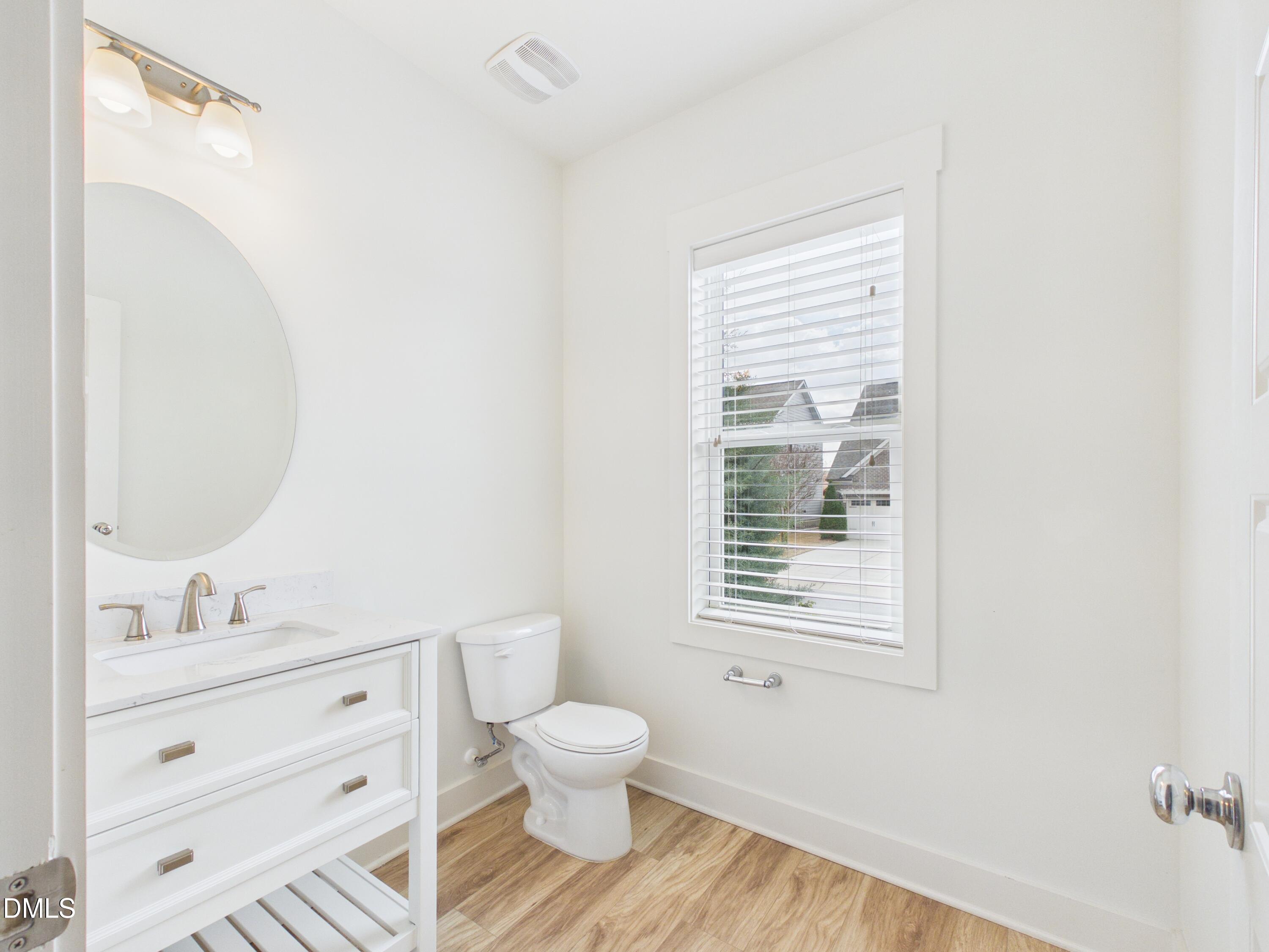 748 Groveview Wendell, NC 27591 - Photo 8 of 38 a bathroom with a toilet sink a mirror and next to a window