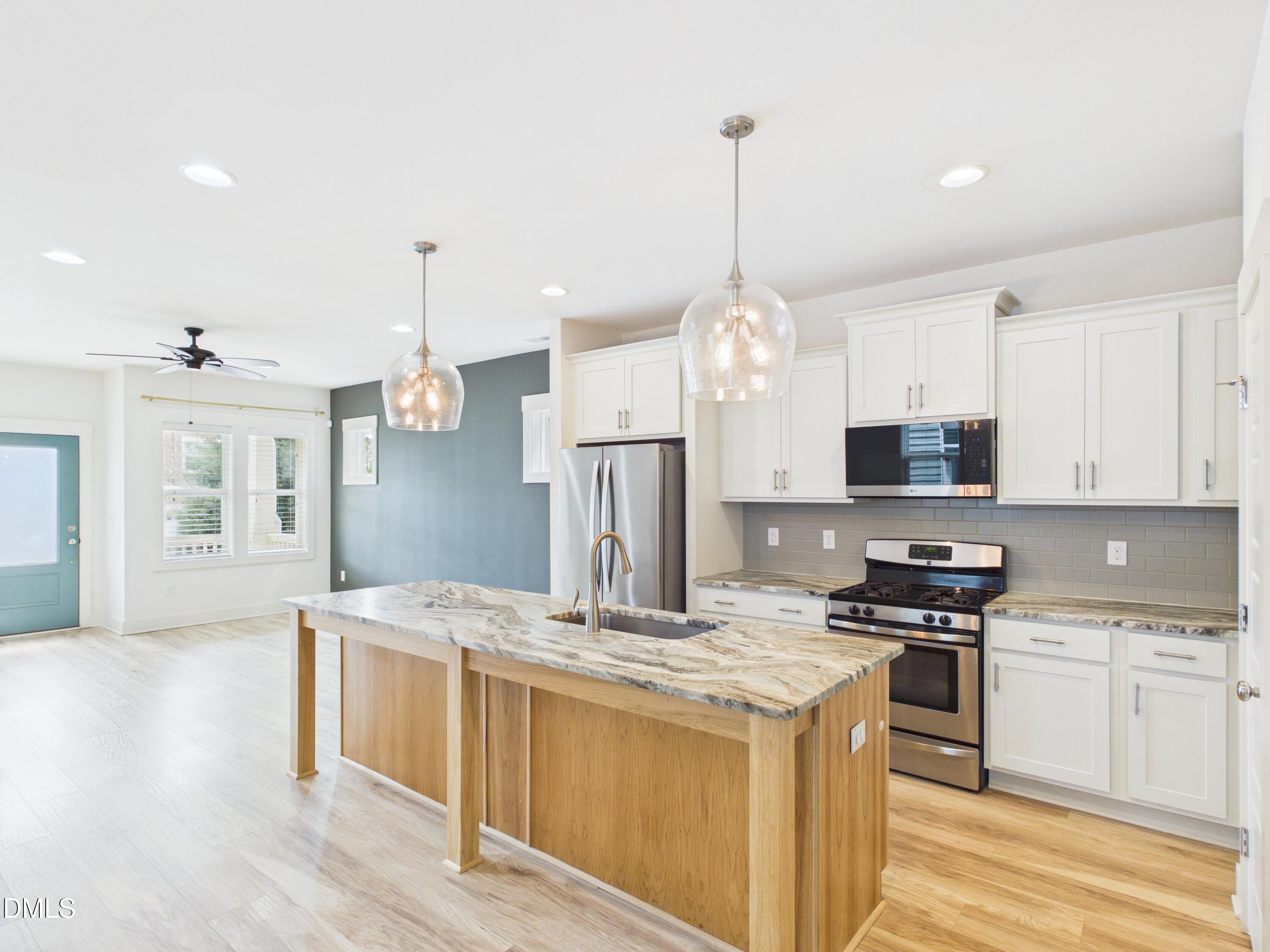 748 Groveview Wendell, NC 27591 - Photo 10 of 38 a kitchen with stainless steel appliances kitchen island granite countertop a stove a sink dishwasher and a refrigerator with wooden floor