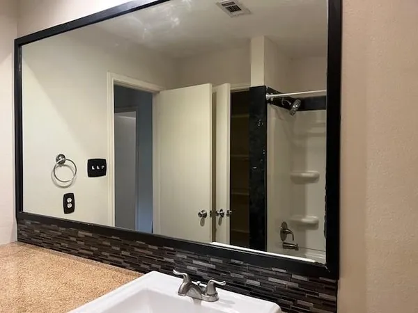 a bathroom with a granite countertop sink and a toilet