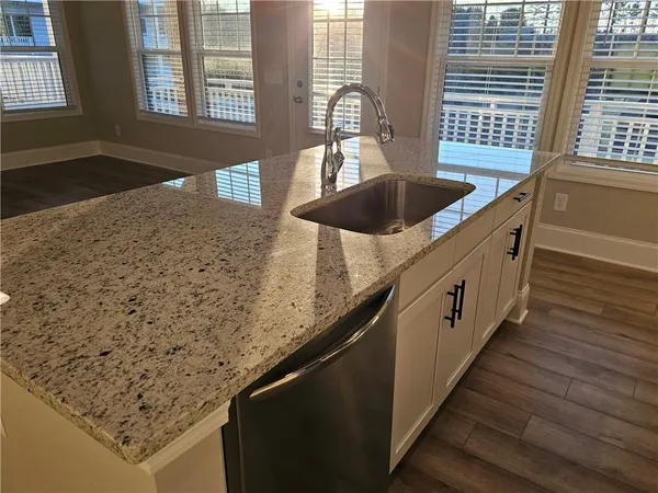 a kitchen with granite countertop sink and cabinets