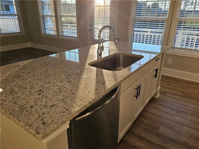 a kitchen with granite countertop sink and cabinets